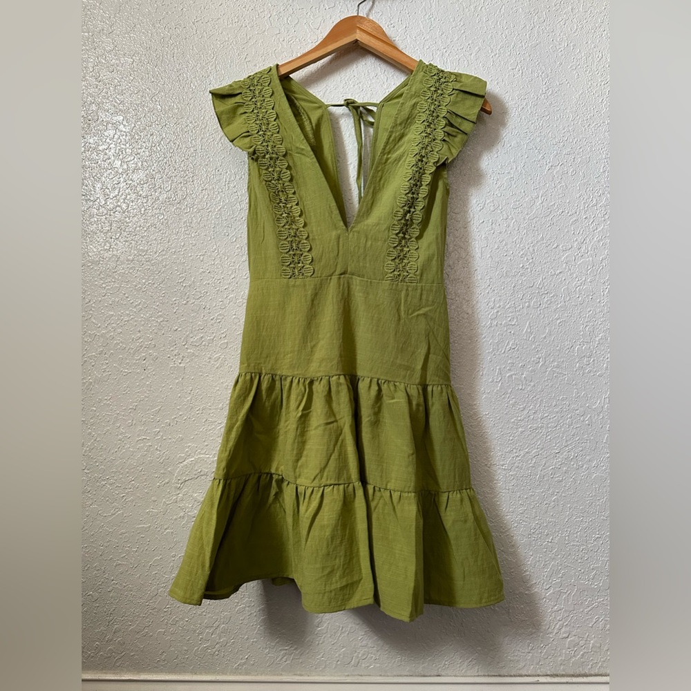women's dress is wide green and is New